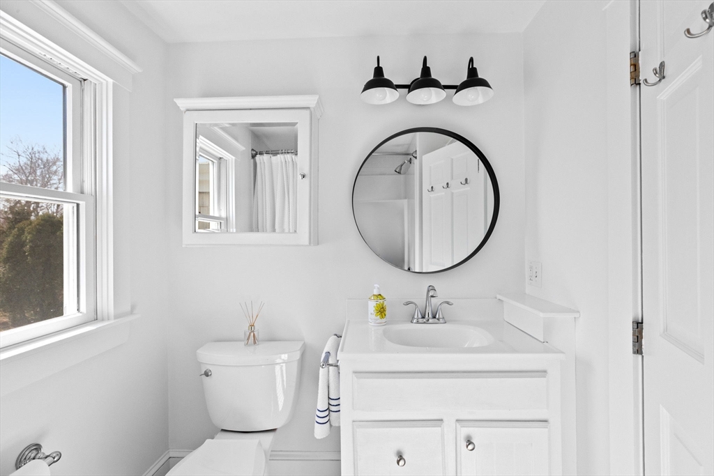 59 Gannett Road Scituate, MA 02066 - Photo 26 of 40 a bathroom with a toilet a sink and a mirror
