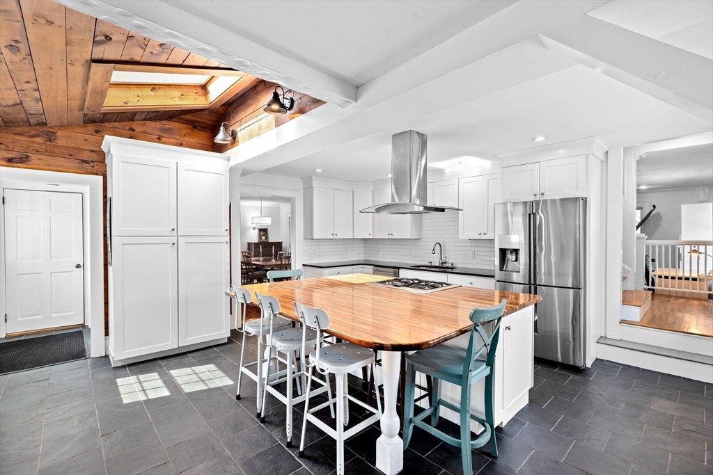 59 Gannett Road Scituate, MA 02066 - Photo 4 of 40 a kitchen with stainless steel appliances granite countertop a table chairs and a refrigerator
