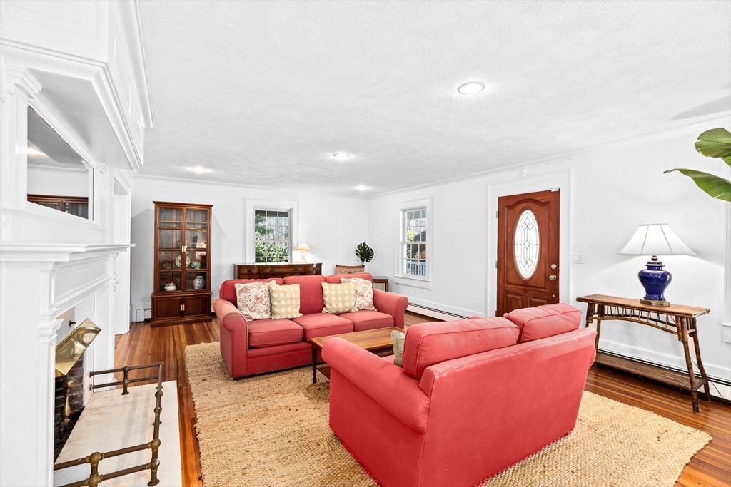 59 Gannett Road Scituate, MA 02066 - Photo 5 of 40 a living room with furniture a fireplace and a window