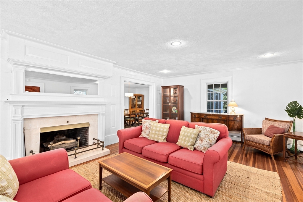 59 Gannett Road Scituate, MA 02066 - Photo 7 of 40 a living room with furniture a fireplace and a table