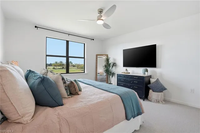 a bedroom with a bed tv and a window