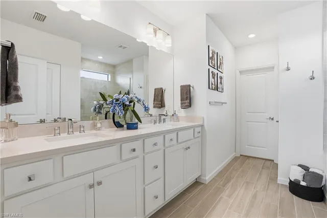 a spacious bathroom with a double vanity sink and mirror