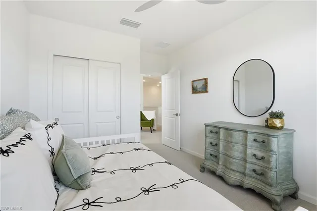 a bedroom with a bed a mirror and a table