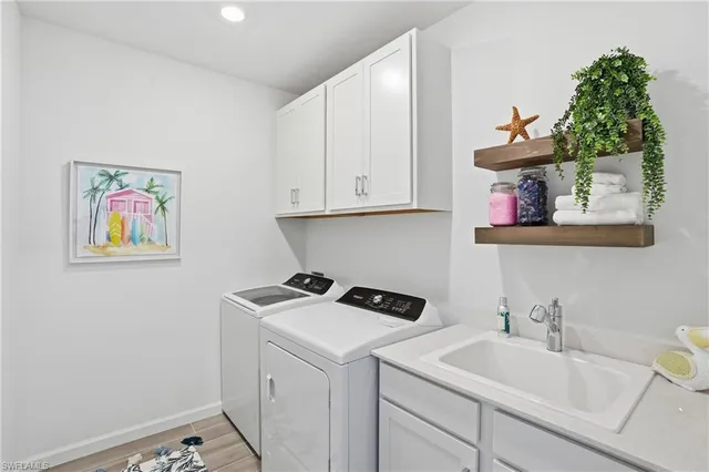 a view of a sink and cabinets with wooden floor
