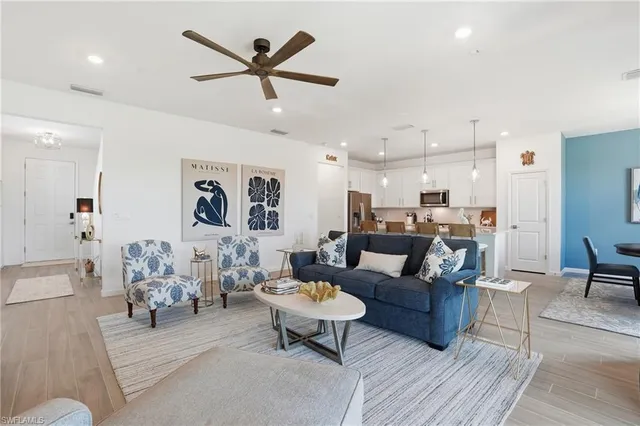 a living room with furniture kitchen view and a chandelier