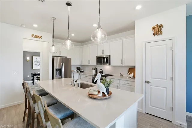 a kitchen with stainless steel appliances kitchen island granite countertop a table chairs and cabinets
