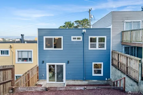 a view of a house with backyard and deck