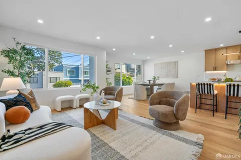 a living room with furniture kitchen view and a large window