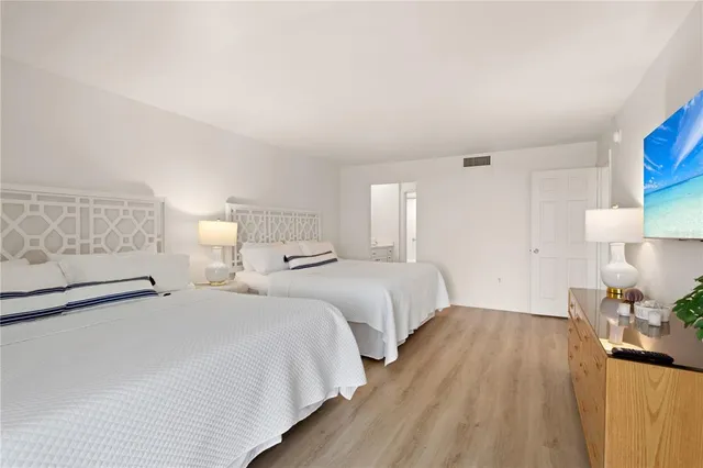 a bedroom with two bed and a night stand