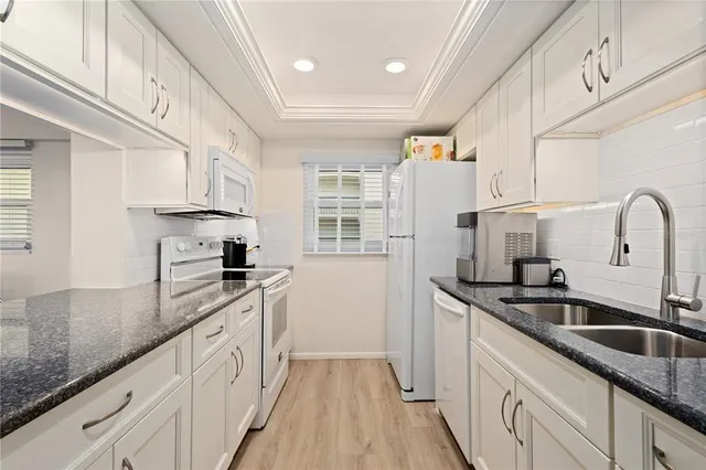 a kitchen with granite countertop a sink and wooden cabinets