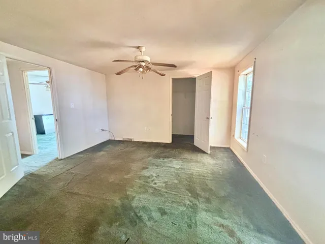 en empty room with windows and fan