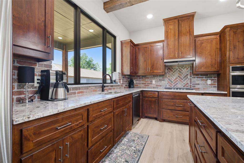 958 Cedar Mills Road Gordonville, TX 76245 - Photo 9 of 40 a kitchen with stainless steel appliances granite countertop sink stove and cabinets