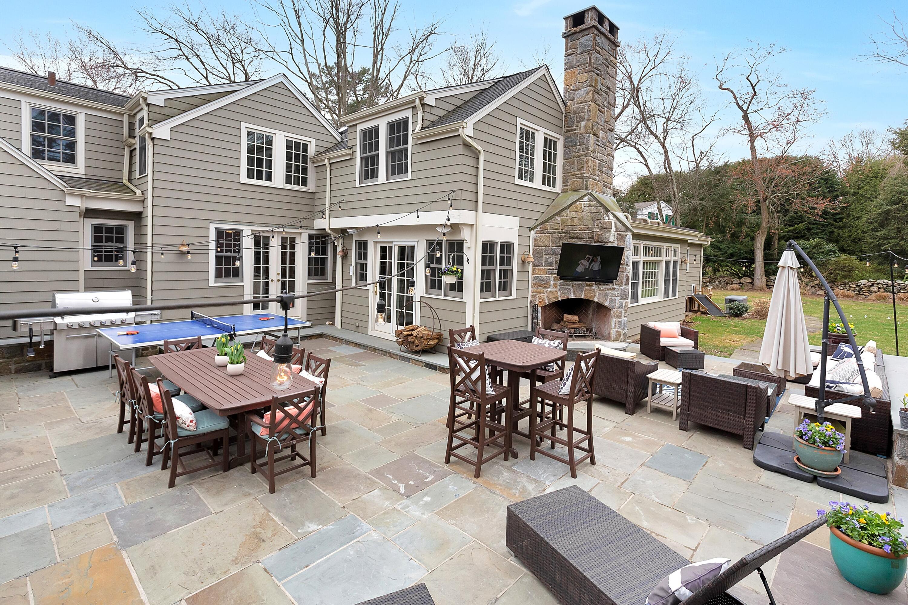 36 Sunset Road Darien, CT 06820 - Photo 30 of 38 a backyard of a house with fire pit table and chairs