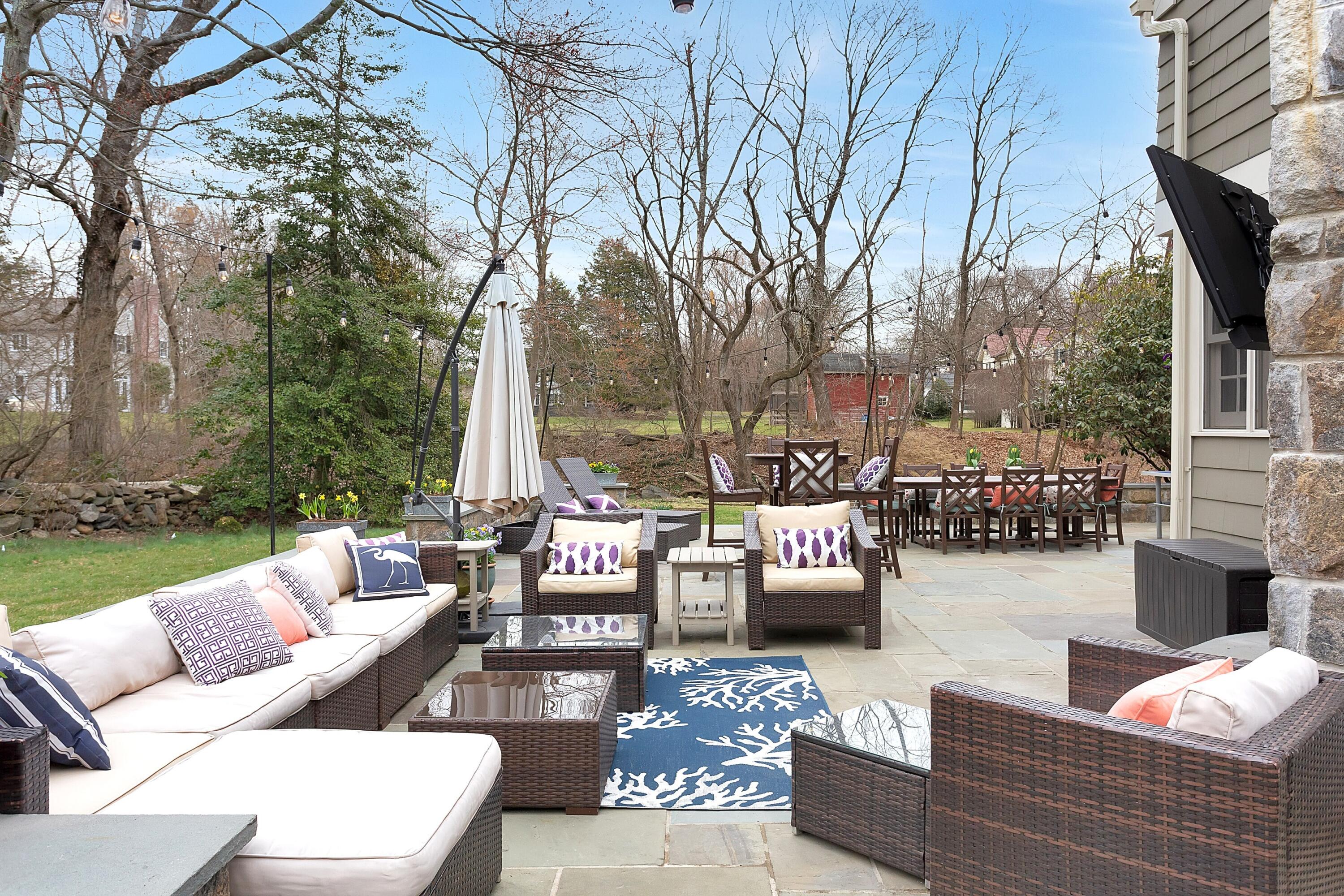 36 Sunset Road Darien, CT 06820 - Photo 32 of 38 a view of a patio with couches and a fire pit and large trees