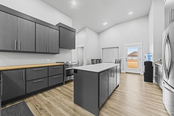 a kitchen with stainless steel appliances granite countertop refrigerator a sink and wooden cabinets