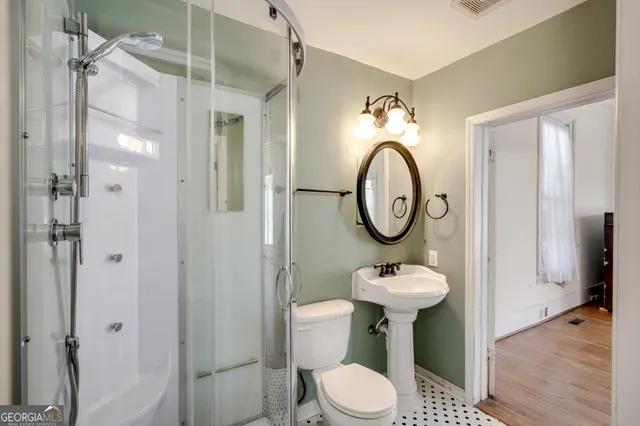 a bathroom with a toilet sink and shower