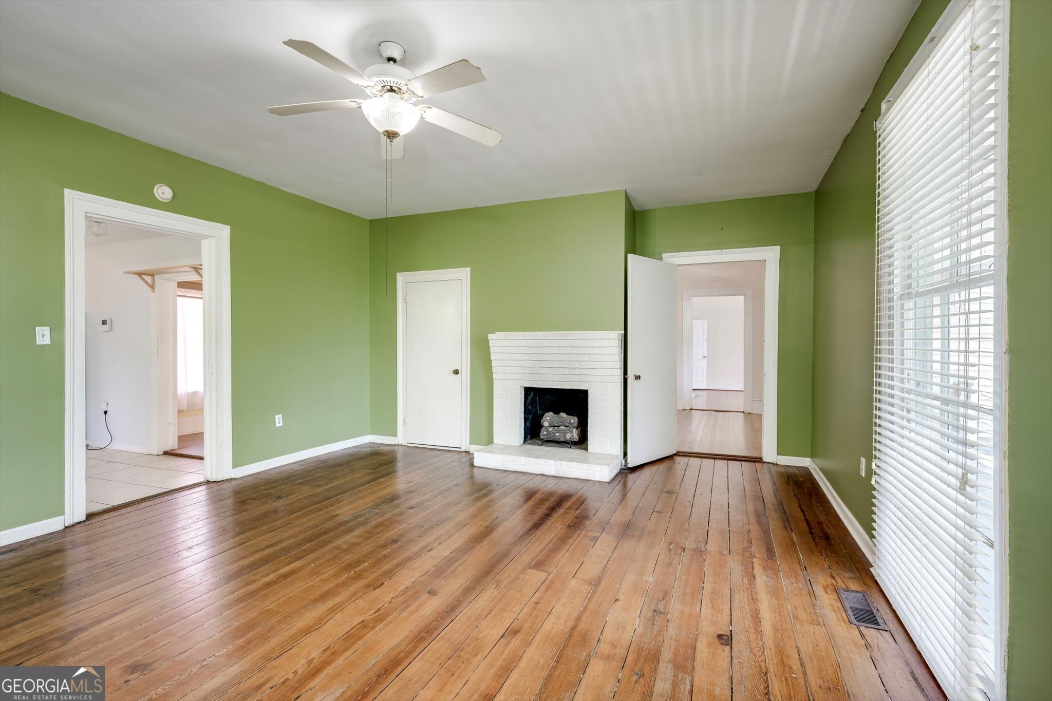 314 White Oak Street Thomson, GA 30824 - Photo 4 of 14 a view of a livingroom with a fireplace a ceiling fan and windows