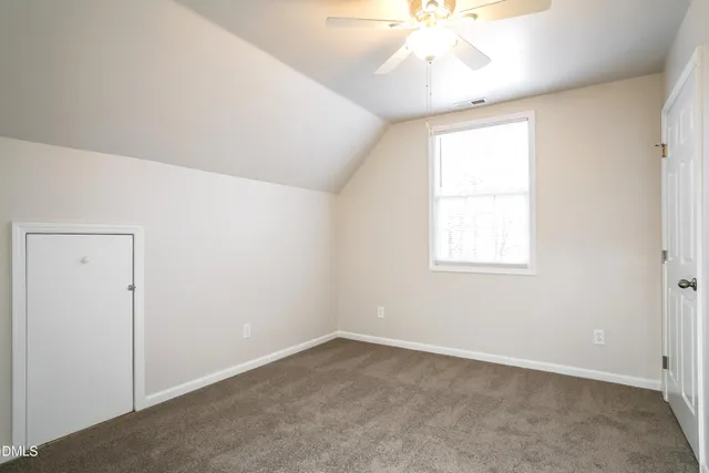 an empty room with a window and a chandelier fan