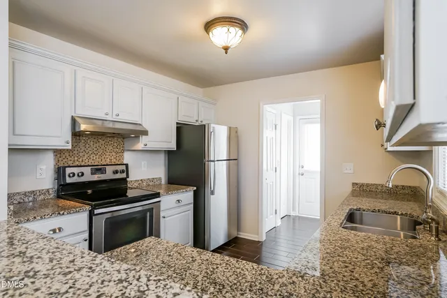 a kitchen with a refrigerator and a stove top oven