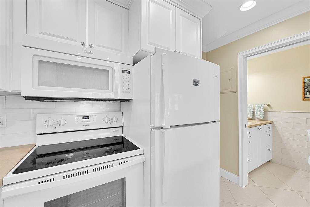 1110 North Riverside Drive, Unit 24 Pompano Beach, FL 33062 - Photo 27 of 43 Bedroom and Bathroom just off the Kitchen. Updated Kitchen with Beautiful Cabinets, Stylish Countertops, White Whirlpool Appliances, Large White Subway Tile Backsplash, 18" Ceramic Tile Floors same though entire condo, Built-in Dining Table for 2, Snack Bar, Cooking Prep Area. Lots of Cabinet Storage, Crown Molding Throughout Condo and Lots of Lighting.