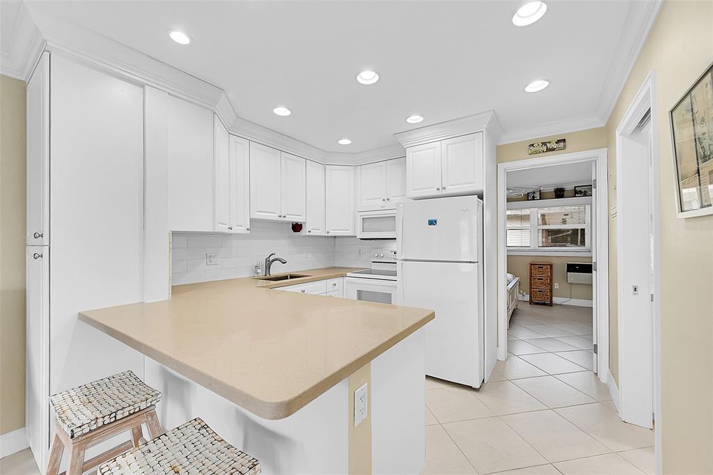 1110 North Riverside Drive, Unit 24 Pompano Beach, FL 33062 - Photo 5 of 43 Updated Kitchen with Beautiful Cabinets, Stylish Countertops, White Whirlpool Appliances, Large White Subway Tile Backsplash, 18" Ceramic Tile Floors same though entire condo, Built-in Dining Table for 2, Snack Bar, Cooking Prep Area. Lots of Cabinet Storage, Crown Molding Throughout Condo and Lots of Lighting. Bedroom and Bathroom just off the Kitchen.