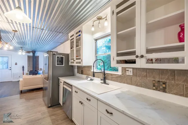 a bathroom with a granite countertop sink vanity mirror and toilet