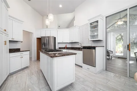 a kitchen with granite countertop a stove top oven and cabinets
