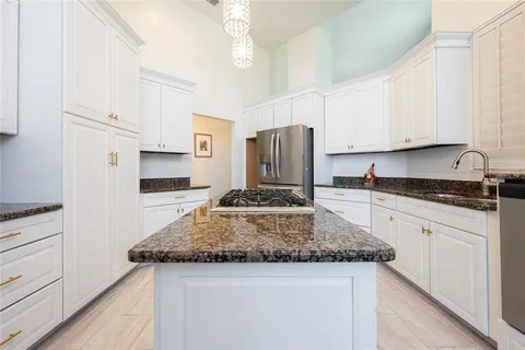 a kitchen with kitchen island granite countertop a sink appliances cabinets and counter space