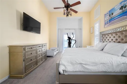 a spacious bedroom with a bed and a flat screen tv