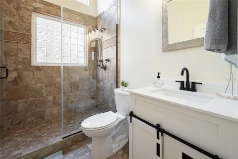 a bathroom with a sink a toilet and shower