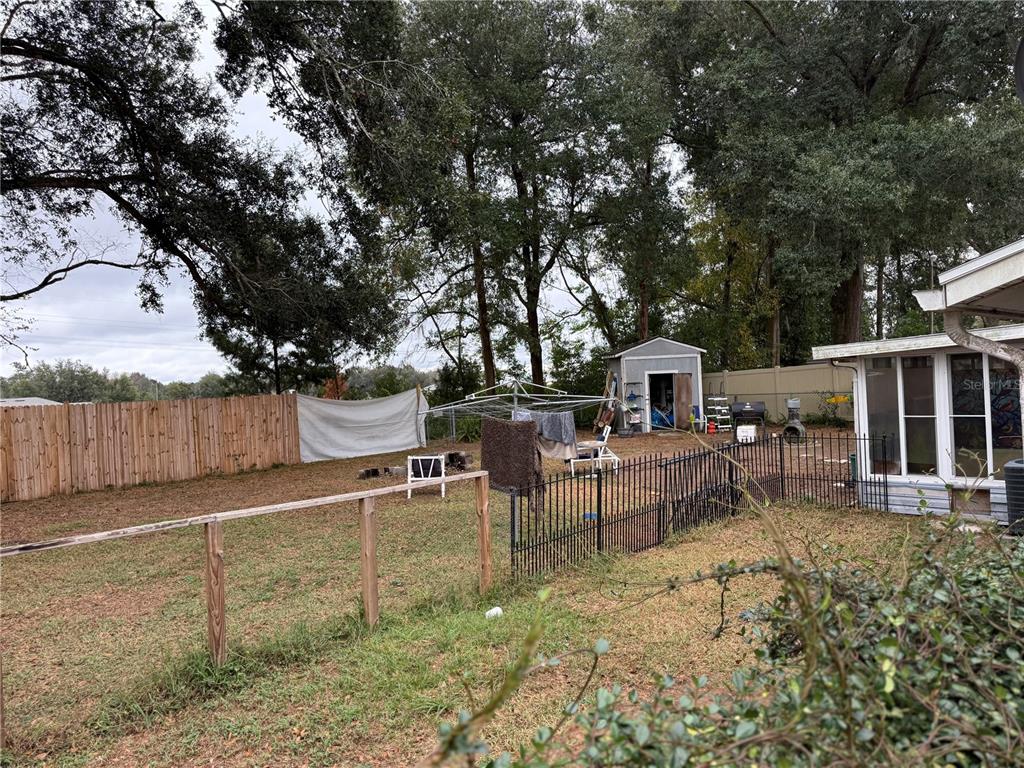 11305 Southeast 76th Avenue Belleview, FL 34420 - Photo 2 of 6 a view of a patio with table and chairs potted plants and a large tree