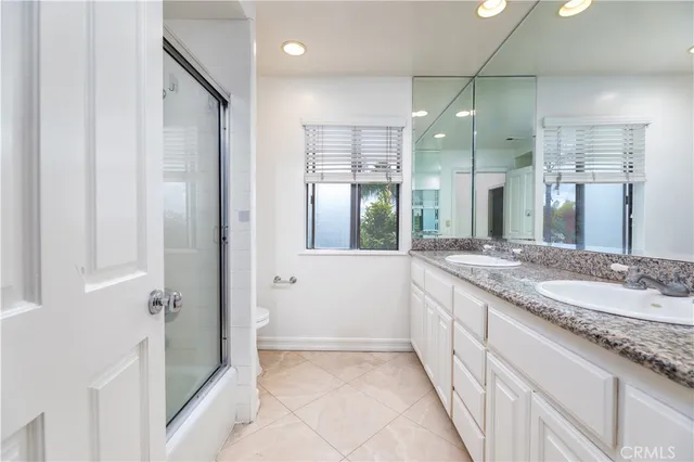 a bathroom with a granite countertop sink a large mirror and a shower