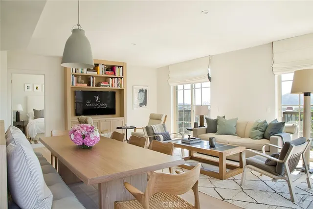 a living room with furniture a flat screen tv and a table