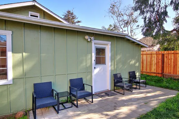 a backyard of a house with chairs and table