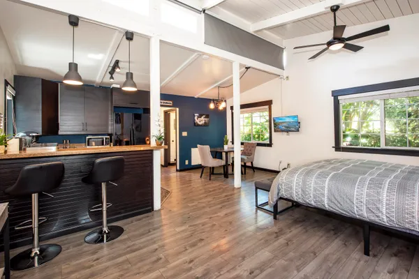 a living room with a bed furniture and a wooden floor