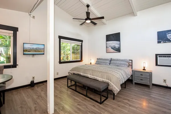 a spacious bedroom with a bed and a flat screen tv