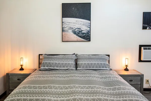 a bedroom with a bed and a painting on the wall