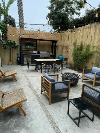 a view of a chairs and table in the back yard of the house