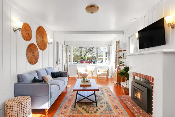 a living room with furniture a flat screen tv and a fireplace