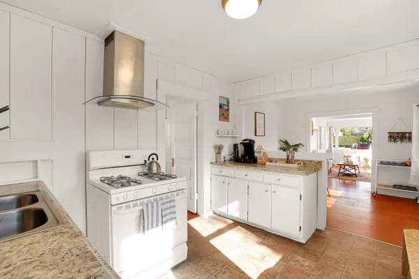a kitchen that has a sink a stove and cabinets