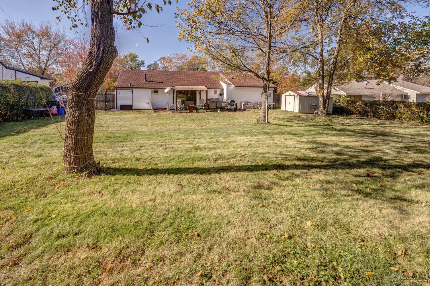 30 Cambridge Road Kendall Park, NJ 08824 - Photo 33 of 43 a large pool that has lawn chairs under an umbrella