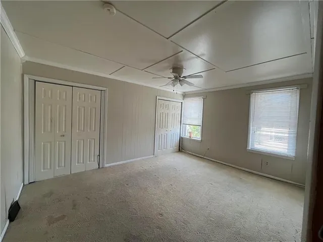 an empty room with windows and closet