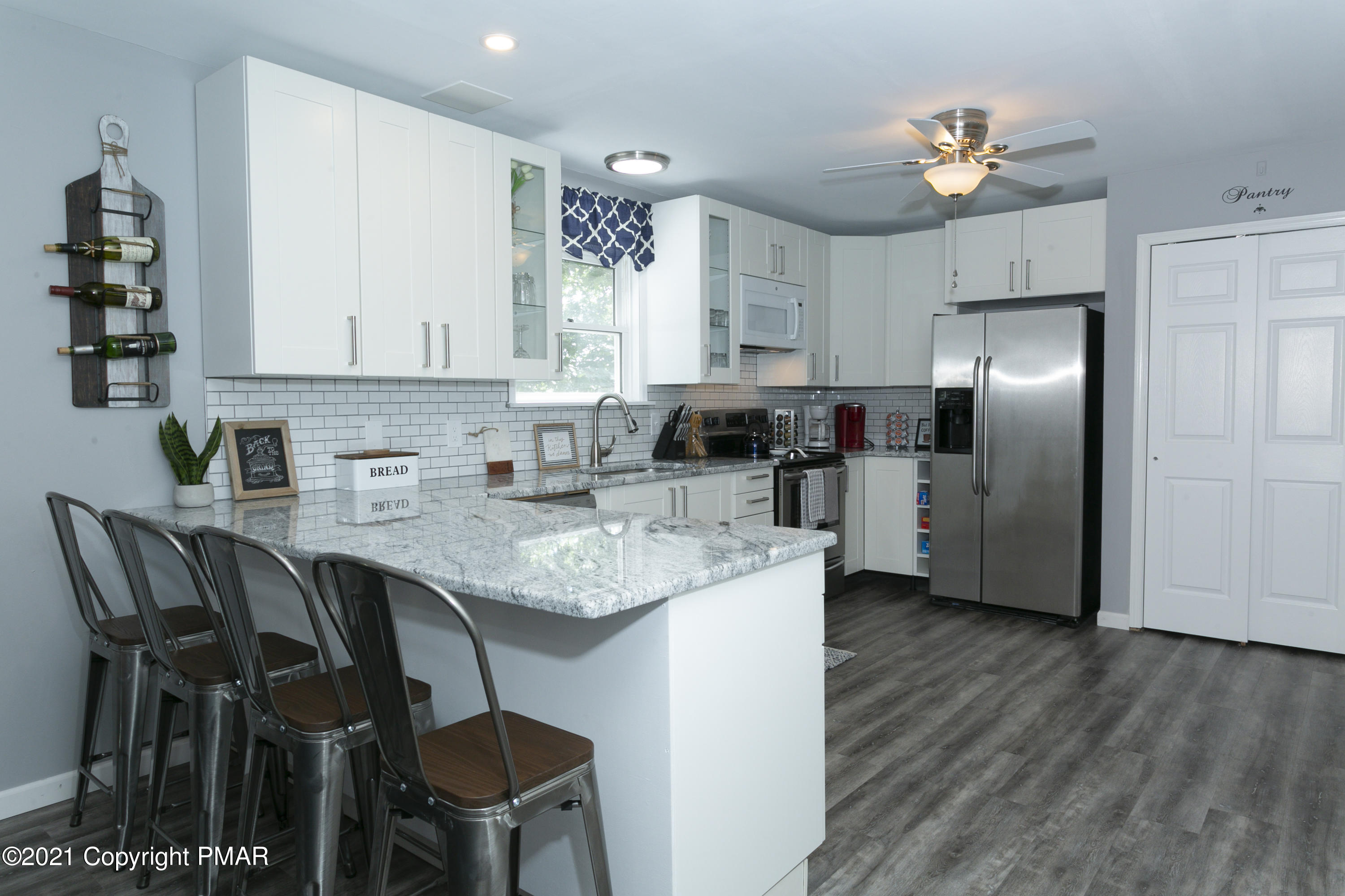 2155 Lancaster Drive Bushkill, PA 18324 - Photo 8 of 57 a kitchen with stainless steel appliances granite countertop a table chairs stove and refrigerator