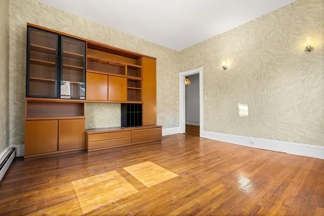 a view of empty room with wooden floor and cabinet