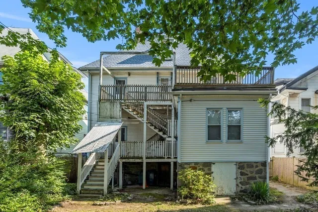 a front view of a house with a tree