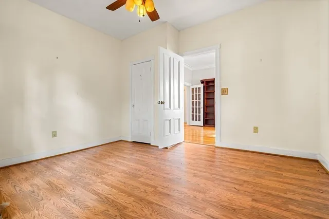 an empty room with wooden floor and natural light
