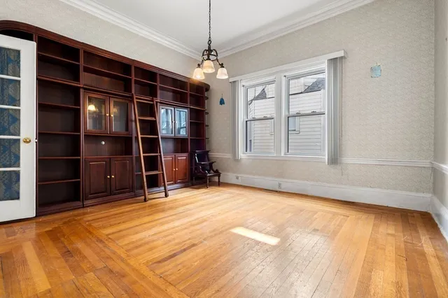 a view of an empty room with a cabinet and a window