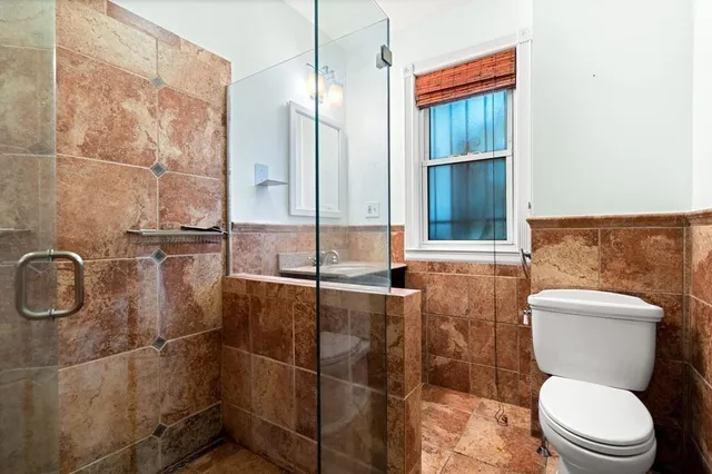 a bathroom with a toilet and a shower