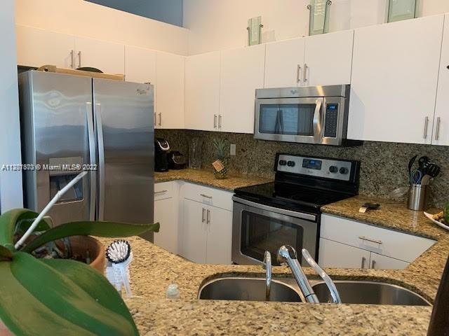 Savanna Weston, FL 33327 - Photo 12 of 24 a kitchen with stainless steel appliances granite countertop a sink a stove and a refrigerator