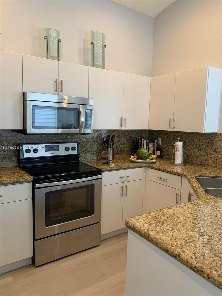 Savanna Weston, FL 33327 - Photo 14 of 24 a kitchen with stainless steel appliances granite countertop a sink stove and cabinets